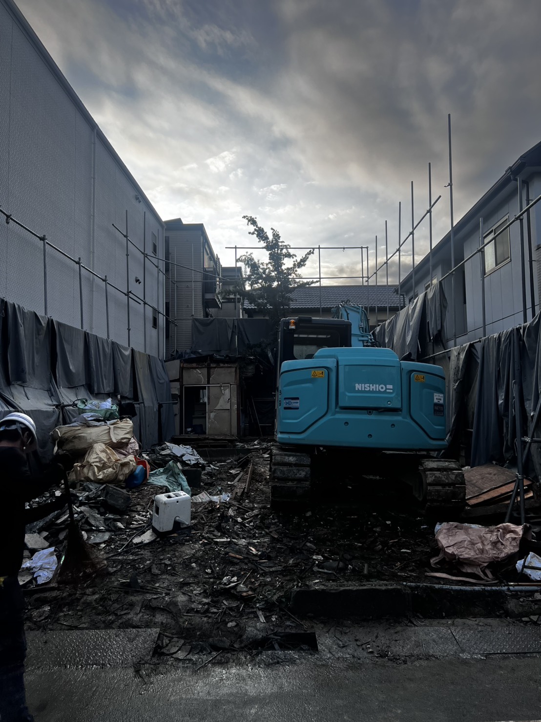 大阪市 木造解体工事 住宅密集地にて重機（NISHIO）を使用し、増築部分を含む家屋を慎重に解体中