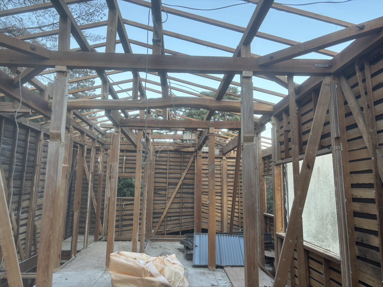 関西 解体工事 木造家屋の構造材（柱・梁）を露出させ、手作業と重機を併用して解体中
