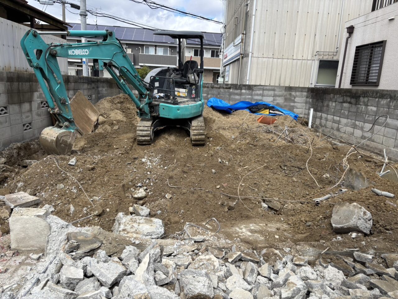 2階解体後に小型重機を搬入し、建物の基礎コンクリートの掘り起こしと廃材の分別を行う作業風景